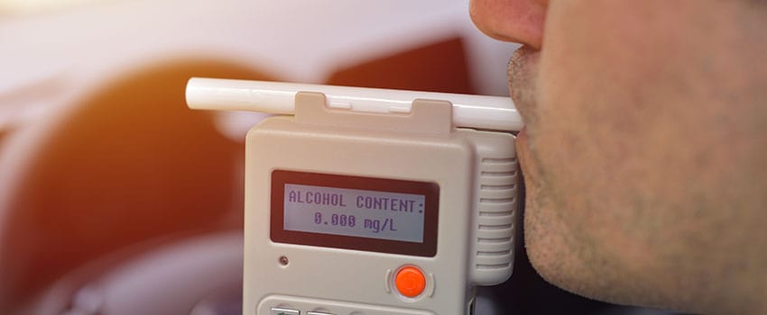 Man Blowing Into Breathalyzer During DUI Stop